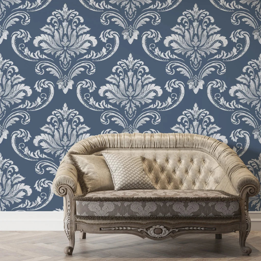 Navy and silver damask wallpaper with ornate baroque pattern behind vintage tufted sofa