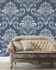 Navy and silver damask wallpaper with ornate baroque pattern behind vintage tufted sofa