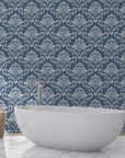 Navy and silver damask Mauve Bloom Essence wallpaper behind white freestanding bathtub in spa bathroom