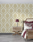 Gold damask Misty Fern Romance wallpaper on cream background in elegant bedroom setting