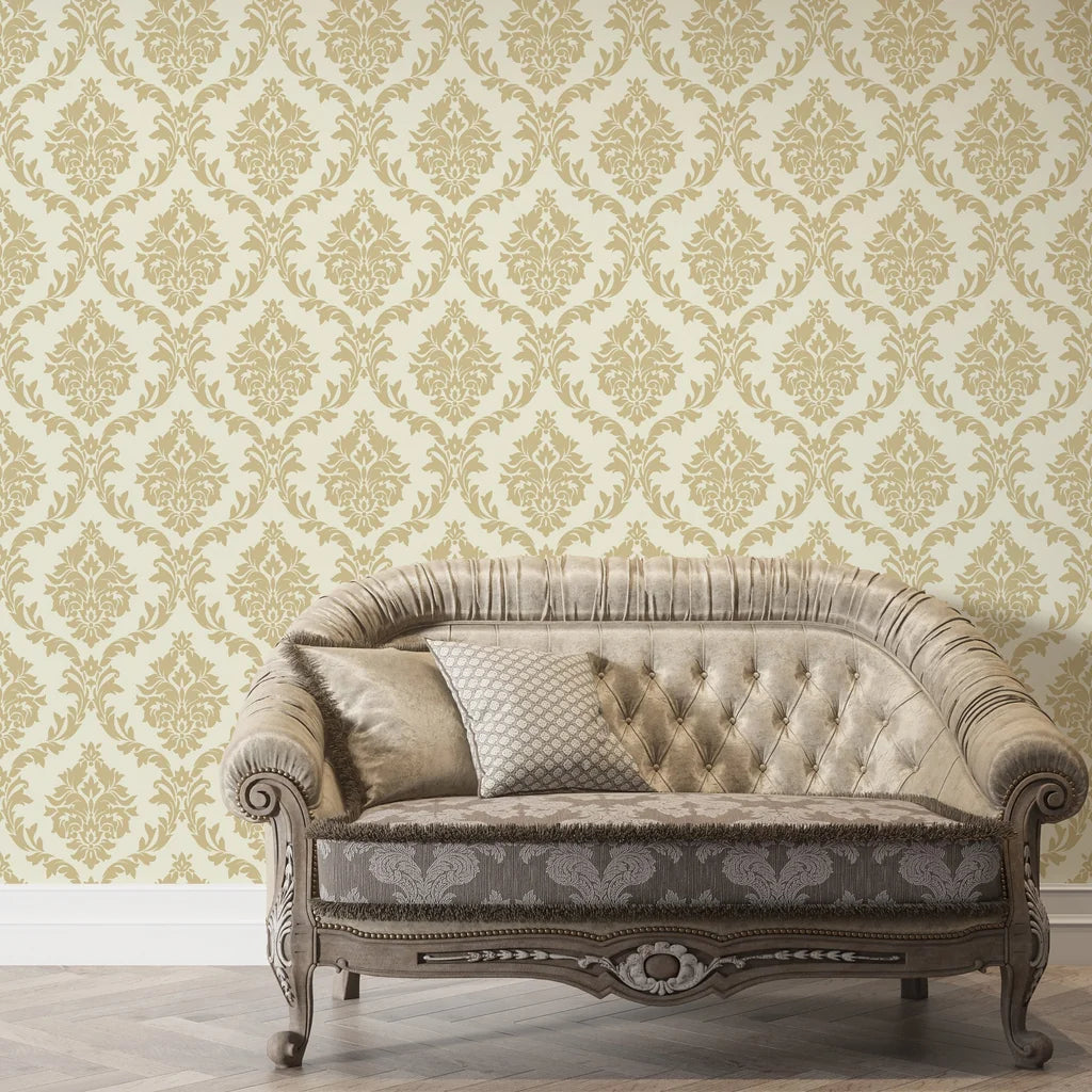 Gold damask Misty Fern Romance wallpaper on cream background with vintage tufted sofa in elegant living room