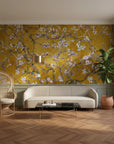 Golden mustard Monet's Garden wallpaper with white cherry blossoms on living room accent wall
