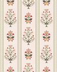 Vertical floral stripe wallpaper with symmetrical folk inspired flowers in red, olive green, and soft peach on a warm cream background.