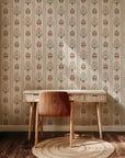 Vertical floral stripe wallpaper with symmetrical folk inspired flowers in red, olive green, and soft peach on a warm cream background.