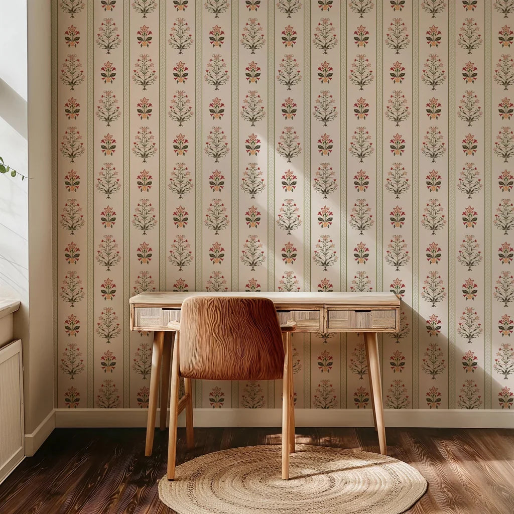 Red, olive green, and soft peach symmetrical folk flowers form a vertical striped pattern on this warm, cream-colored wallpaper