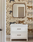 Playful leopard wallpaper with hand illustrated spotted cats in tan, caramel, and black on a soft beige background.
