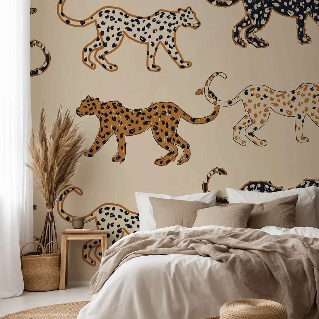 Against a soft beige backdrop, this playful wallpaper displays hand illustrated spotted cats patterned in tones of black, caramel, and tan