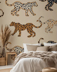 Against a soft beige backdrop, this playful wallpaper displays hand illustrated spotted cats patterned in tones of black, caramel, and tan