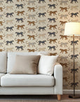 Wallpaper with playful, hand-sketched spotted cats in tan, black, and warm caramel tones, all superimposed on a soft beige backdrop.
