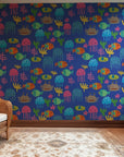 Wallpaper in blue featuring a fun pattern of brightly colored, paper-cut-style ocean life