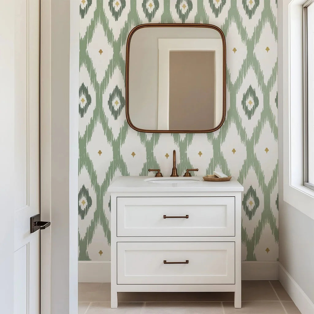 Subtle gold accents highlight the artisanally drawn diamond shapes on this sage green ikat wallpaper. The pattern rests on a clean white backdrop.