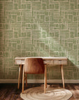 Olive green abstract wallpaper with hand drawn brush stroke blocks arranged in a loose geometric grid on a warm cream background.