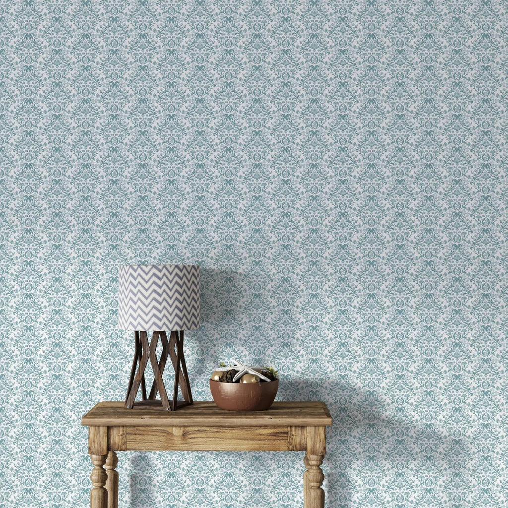 Teal and cream Petal Reflection damask wallpaper shown on living room wall with rustic wood console table