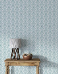 Teal and cream Petal Reflection damask wallpaper shown on living room wall with rustic wood console table