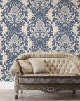 Poet's Blossom damask wallpaper in slate blue and cream behind vintage tufted sofa in elegant living room