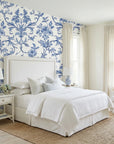 Porcelain Garden elegant blue chinoiserie floral wallpaper adding character to a cozy bedroom