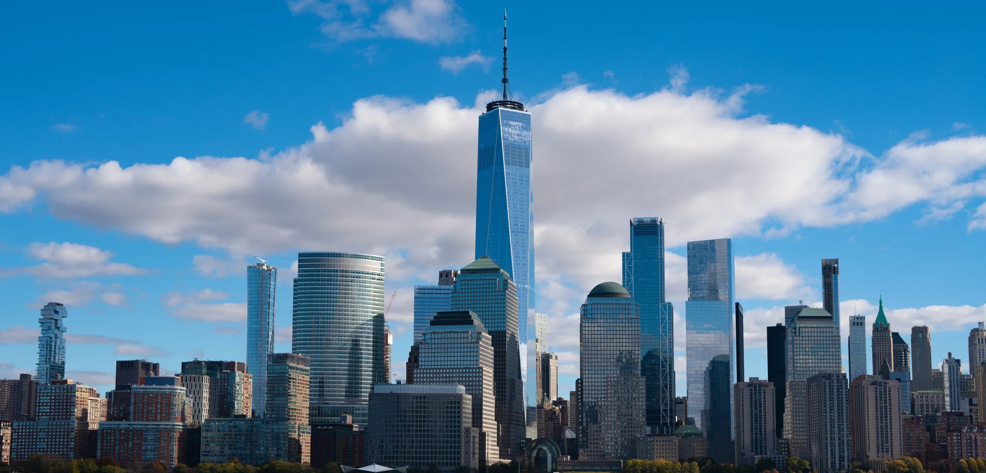 Modern Rising cityscape wallpaper featuring blue glass skyscrapers against dramatic cloudy sky