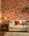 Rust Echoes bold leaf wallpaper in a warm and inviting living room
