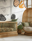 Safari themed wallpaper shown in a modern children’s room with minimalist furniture and warm textures
