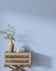 Blue and white Secret Arbor geometric wallpaper styled with rustic wood dresser and botanical decor