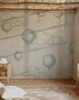 White, airy wall paper displaying an illustration of blue, outlined balloons and fluffy clouds.