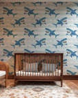 Whimsical, underwater-themed wallpaper showing blue sharks that are winking amidst a striped background.