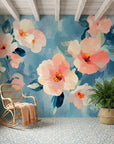 Soft Scatter watercolor floral wallpaper featuring coral pink blooms on teal blue accent wall in coastal cottage room