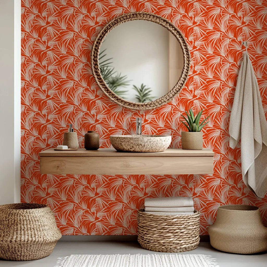 A bright orange wallcovering adorned with a white tropical palm frond pattern, called Solar Fronds