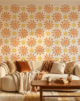 Vibrant orange folk art sun swirl peel and stick wallpaper - Solstice Bloom in a warm living room