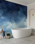 Navy and teal Starlit Dreams celestial wallpaper with stars and clouds in modern bathroom setting
