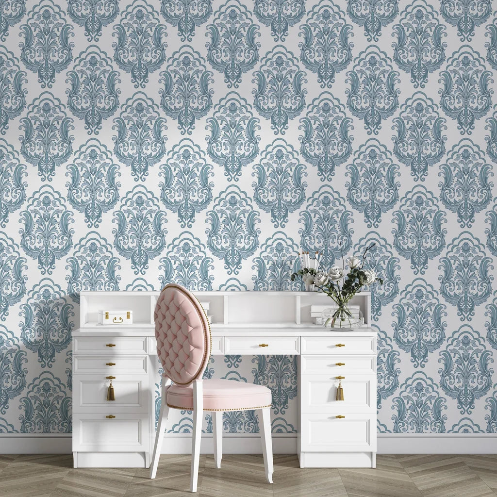 Slate blue and cream damask Sunlit Thicket wallpaper creating elegant accent wall behind white vanity desk