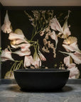 Blush pink tulips and baby's breath botanical wallpaper on dark background in modern bathroom setting