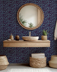 Deep violet wall covering displaying a blue, stylized floral vine motif (Twilight Bloom)