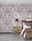 Burgundy and cream Wildwood Silk damask wallpaper on bedroom accent wall with vintage furniture