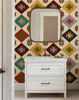Warmly toned wall paper in a desert-inspired aesthetic, showcasing angular diamond tessellations. The specific colors are sage green, mustard yellow, ivory, charcoal, rust red, and teal.