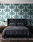Antique Fern Mist Teal distressed damask wallpaper behind a tufted headboard in a dark, moody bedroom