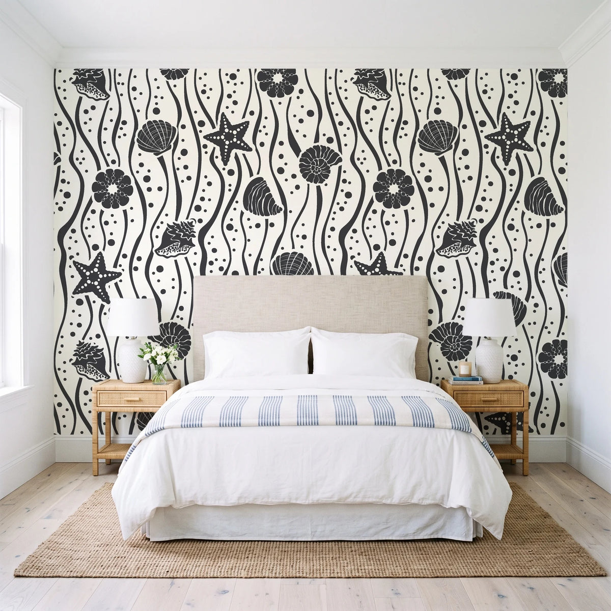 Apricot Tides Charcoal coastal seashell wallpaper behind a queen bed in a bright coastal bedroom
