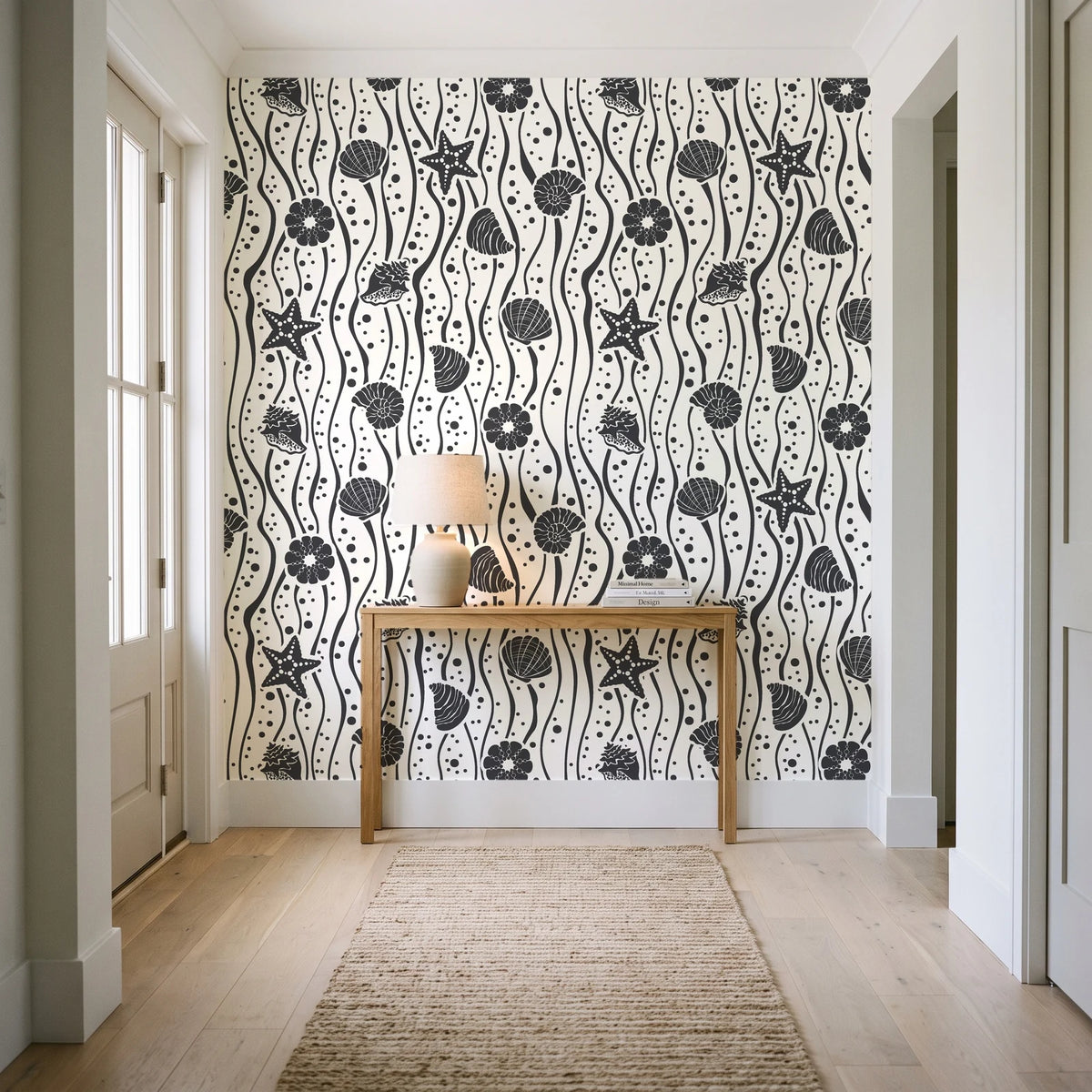 Apricot Tides Charcoal coastal seashell wallpaper behind a console table in a light entry hallway