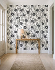 Apricot Tides Charcoal coastal seashell wallpaper behind a console table in a light entry hallway
