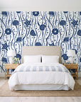 Apricot Tides Navy coastal seashell wallpaper behind a queen bed in a bright coastal bedroom