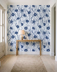 Apricot Tides Navy coastal seashell wallpaper behind a console table in a light entry hallway