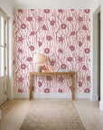 Apricot Tides Rosewood coastal seashell wallpaper behind a console table in a light entry hallway