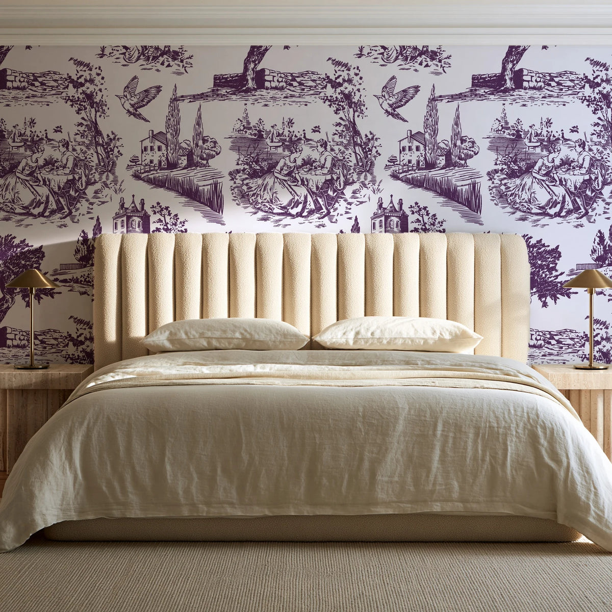 Arcadian Reverie Plum pastoral toile wallpaper behind a channel-tufted bed in a calm primary bedroom