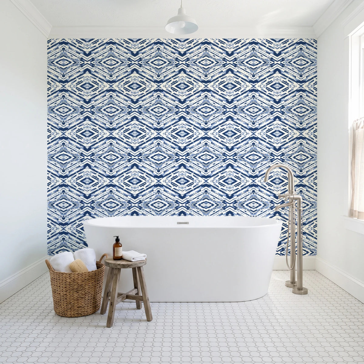 Arrows At Dawn Indigo geometric diamond wallpaper behind a freestanding tub in a bright coastal bathroom
