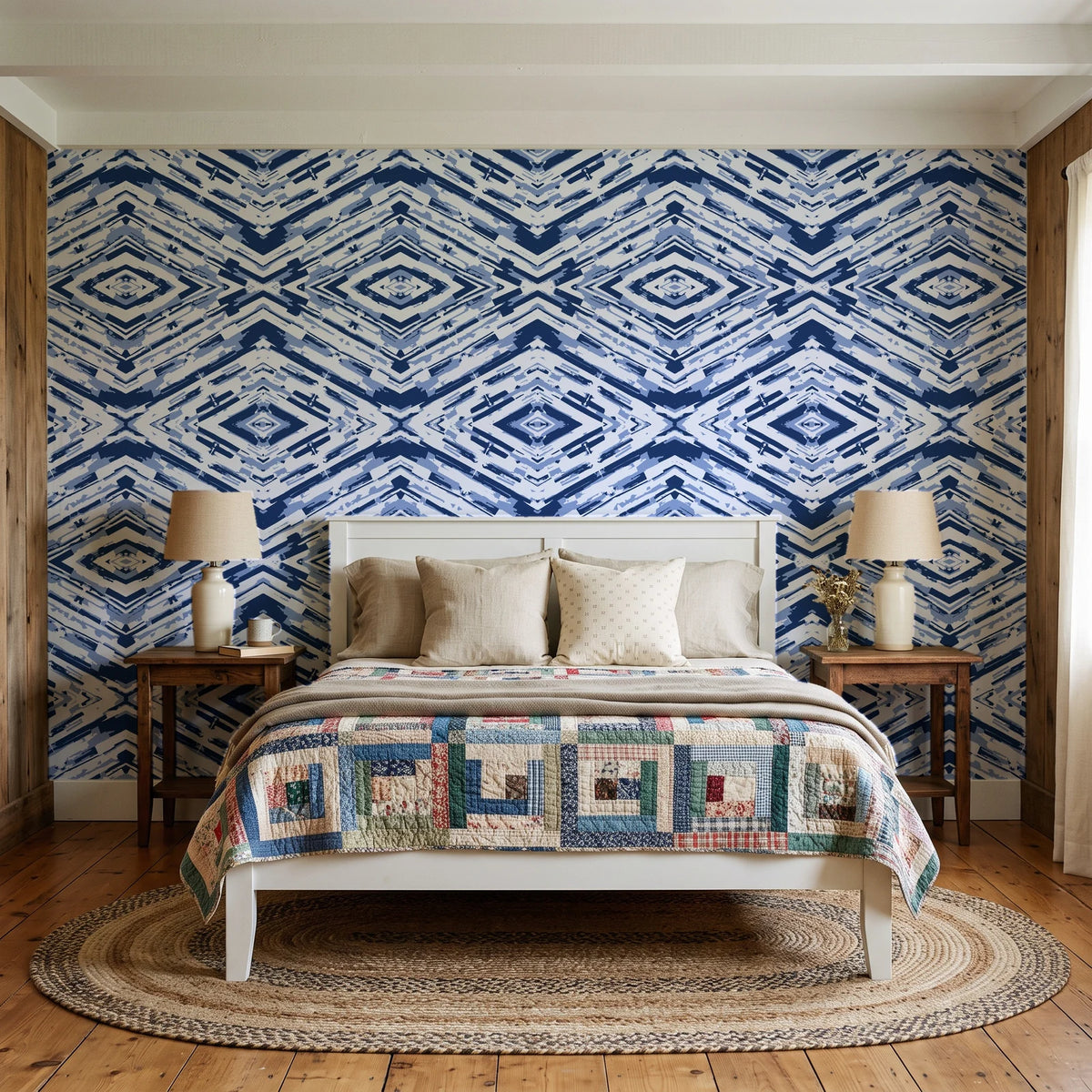 Arrows At Dawn Indigo geometric diamond wallpaper behind a white cottage bed with a patchwork quilt in a cozy cottagecore bedroom