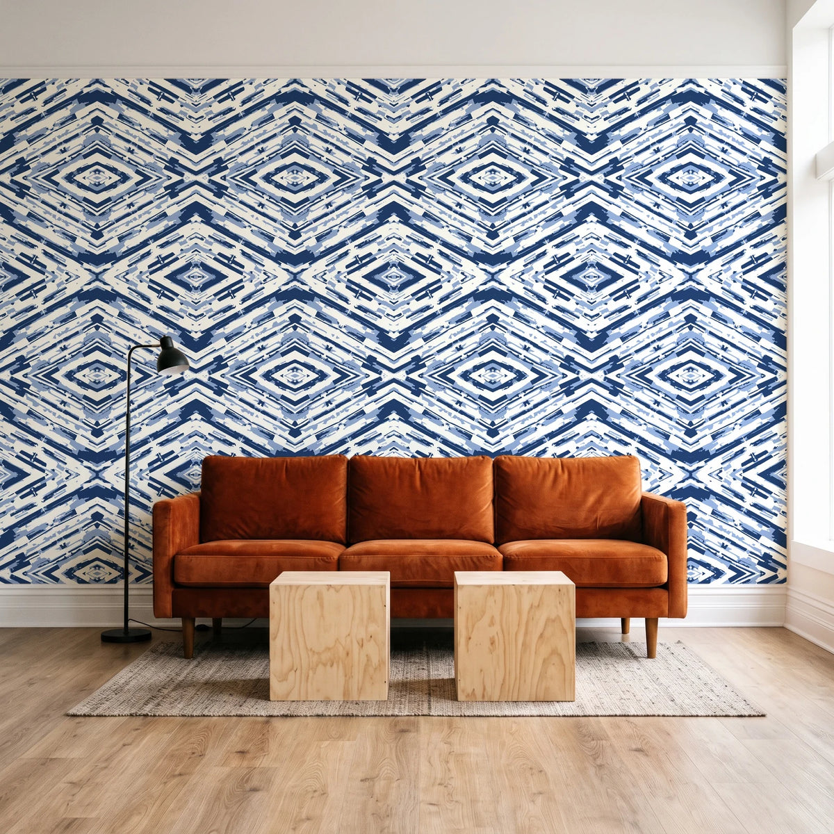 Arrows At Dawn Indigo geometric diamond wallpaper behind a rust velvet sofa in a bright coworking lounge