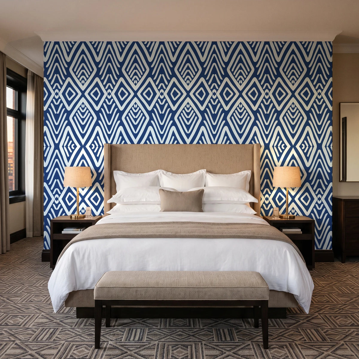 Aztec Quilt Indigo geometric tribal wallpaper behind the headboard of a king bed in a contemporary hotel guest room