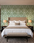 Aztec Quilt Olive geometric tribal wallpaper behind the headboard of a king bed in a contemporary hotel guest room