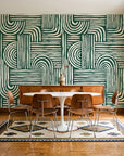 Bantu Lines Emerald brush geometric wallpaper in a mid-century dining room with a teak sideboard and tulip table