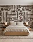 Bantu Lines Espresso brush geometric wallpaper behind a low platform bed in a serene Japandi bedroom